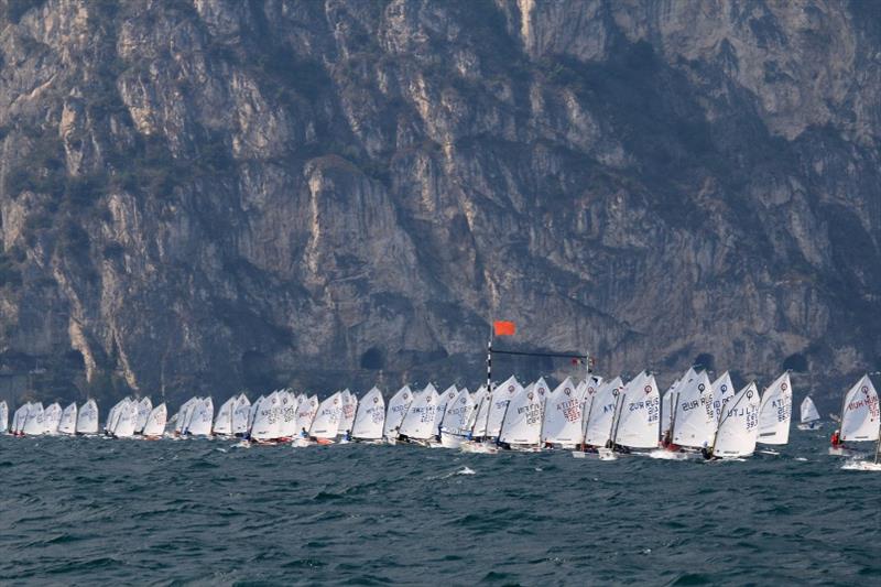 Optimist fleet racing beneath mountains